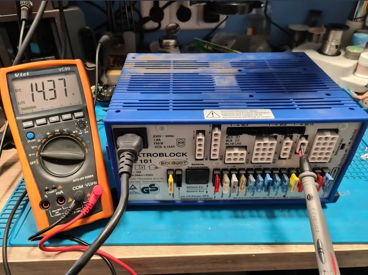Prueba de carga a 230 V sobre Elektroblock EBL 101 — multímetro marcando 14,37 V